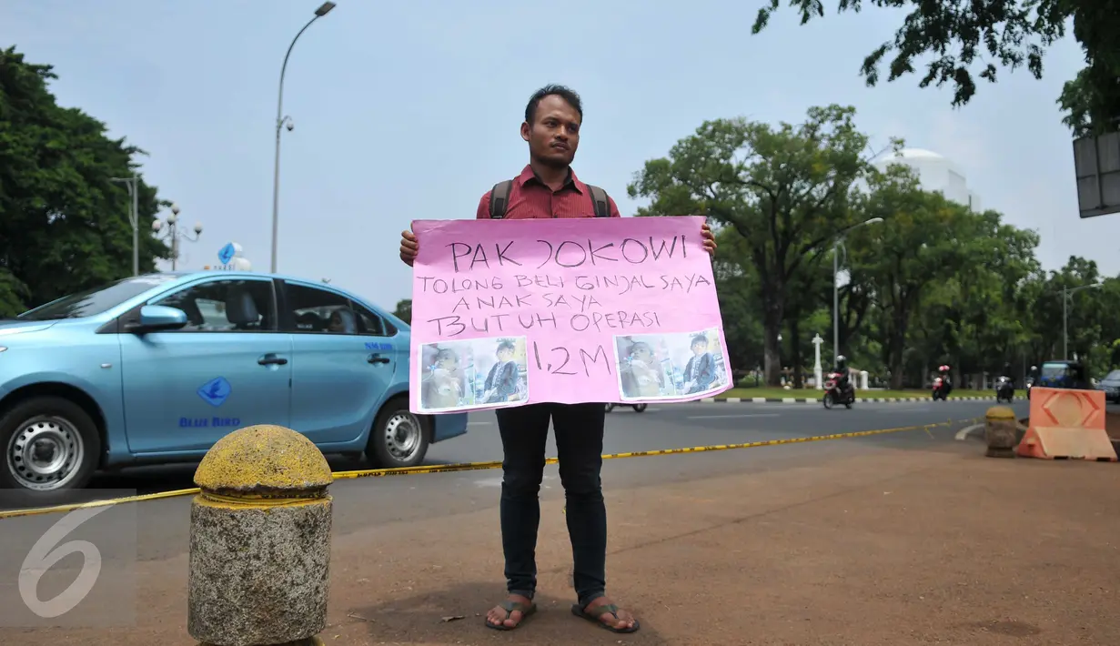 Susanto asal Pandeglang, Banten membawa sebuah karto saat aksi jual ginjal di depan Istana Merdeka, Jakarta, Jumat (20/11). Aksi jual ginjal ke Presiden Jokowi ini untuk biaya operasi anaknya yang disinyalir mencapai Rp.1,2M. (Liputan6.com/Gempur M Surya)