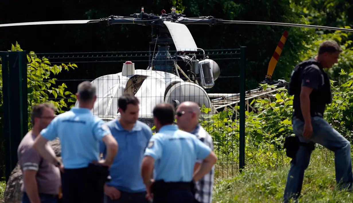 Aparat kepolisian berdiri dekat helikopter yang ditinggalkan seorang gangster terkenal Prancis, Redoine Faid di Gonesse, utara Paris, Minggu (1/7). Faid (46) kabur dari penjara di Reau dengan dijemput helikopter tersebut. (AFP/GEOFFROY VAN DER HASSELT)