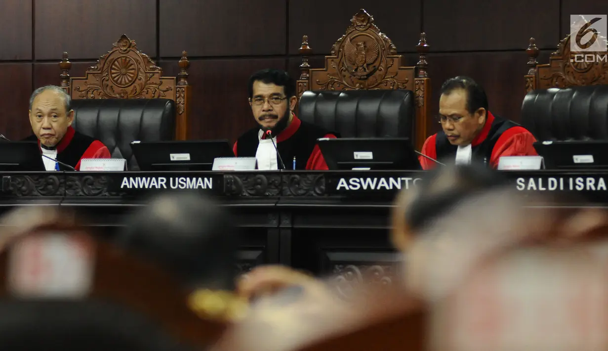 Wakil Ketua MK Anwar Usman (tengah) memimpin sidang lanjutan pengujian UU Jaminan Halal terkait ketentuan produk halal di gedung Mahkamah Konstitusi, Jakarta, Rabu (12/7). Sidang mendengarkan keterangan saksi dan ahli. (Liputan6.com/Helmi Fithriansyah)