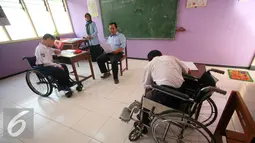 Pengawas membacakan soal kepada siswa berkebutuhan khusus di SLB Negeri 1 Bantul, Yogyakarta, Senin (16/5). Siswa tingkat sekolah dasar melaksanakan ujian nasional secara serentak hingga 25 Mei 2016. (Liputan6.com/Boy Harjanto)