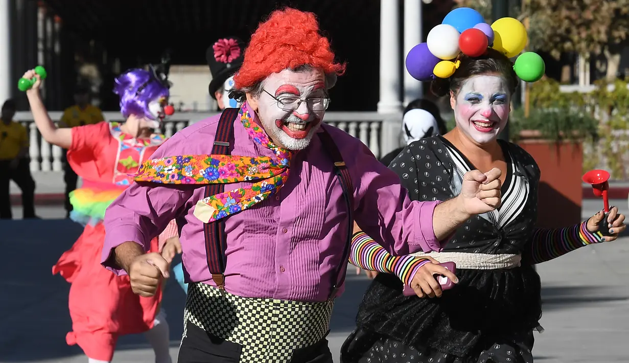 Para peserta berkostum badut berlarian selama acara 'Running of the Clowns' di Pasadena, California pada 21 Oktober 2018. Lari dikejar kawanan badut ini merupakan parodi yang mengolok-olok lomba dikejar banteng di Pamplona, Spanyol. (Mark RALSTON/AFP)