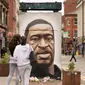 Warga mengamati mural George Floyd di Manchester tengah, Inggris (4/6/2020). George Floyd tewas kehabisan napas saat dalam penahanan pihak kepolisian Negara Bagian Minnesota, wilayah Midwest Amerika Serikat, pada pekan lalu. (Xinhua/Jon Super)