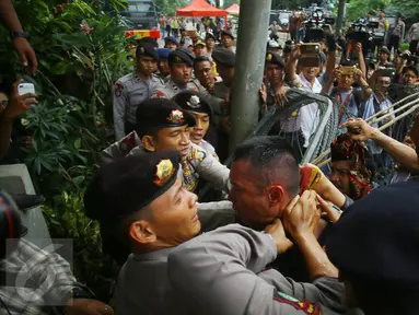 Seorang pria yang diduga provokator diamankan dari amukan massa saat sidang kasus penistaan agama di Jakarta, Selasa (10/1). Sempat terjadi kericuhan akibat peristiwa tersebut. (Liputan6.com/Immanuel Antonius)