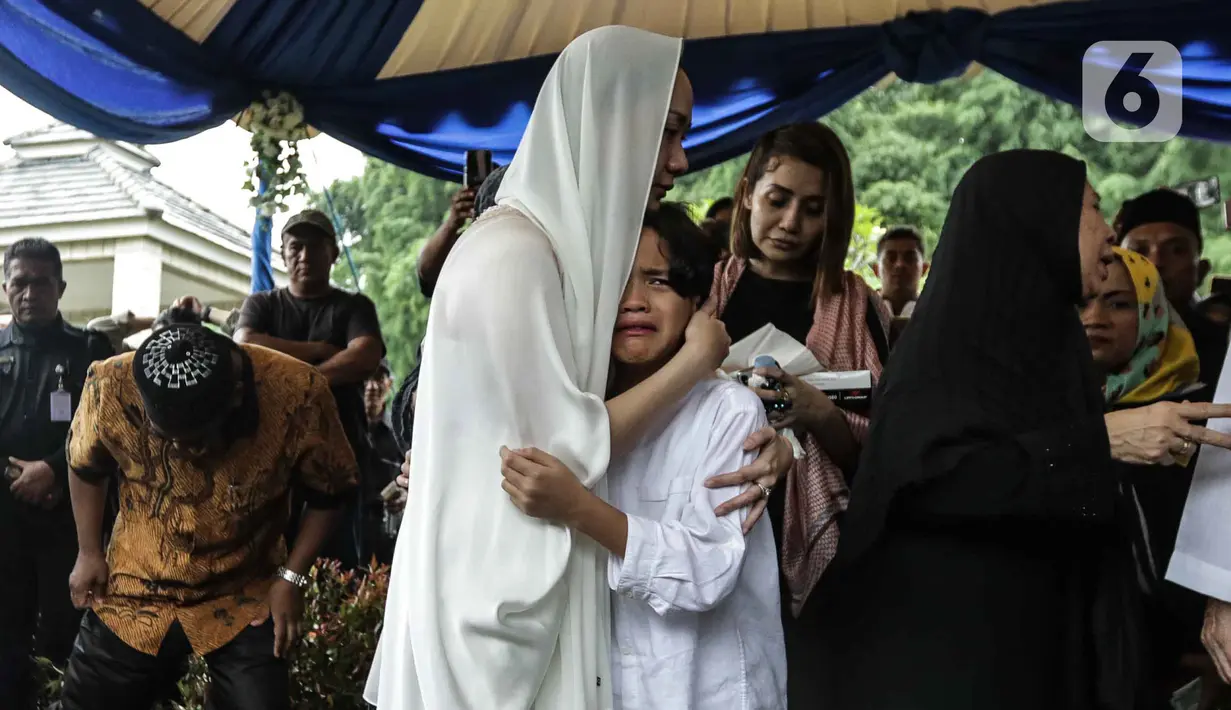 Bunga Citra Lestari atau BCL memeluk putranya Noah Sinclair saat pemakaman jenazah Ashraf Sinclair di San Diego Hills, Karawang, Jawa Barat, Selasa (18/2/2020). Tangis keluarga dan kerabat pecah saat pemakaman Ashraf Sinclair. (Liputan6.com/Faizal Fanani)