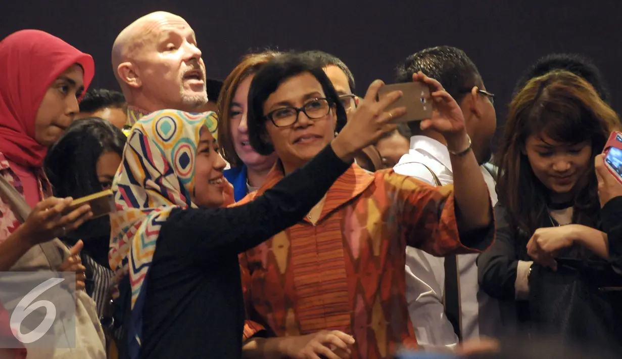 Mantan Menteri Keuangan, Sri Mulyani Indrawati (tengah) berselfie bersama peserta kuliah umum di Kampus UI Depok, Selasa (26/7). Kuliah bertema Peranan Pemuda dalam Mensukseskan Pembangunan Berkelanjutan yang Inklusif. (Liputan6.com/Helmi Fithriansyah)