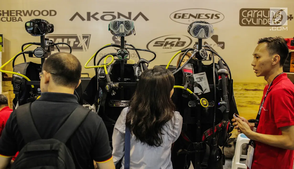 Pengunjung melihat-lihat pakaian diving dalam pameran Deep and Extreme Indonesia (DXI) 2019 di Jakarta, Kamis (4/4). DXI 2019 mengusung tema bersih, nyaman, aman dan nyaman untuk berwisata. (Liputan6.com/Faizal Fanani)