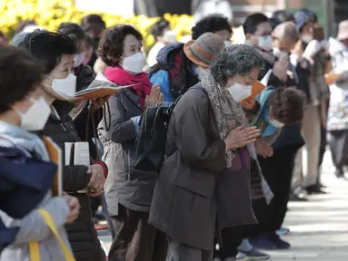 Orang-orang memakai masker untuk mencega virus corona berdoa selama kebaktian di kuil Chogyesa di Seoul, Korea Selatan, Senin (19/10/2020). Korsel pada Senin mulai menguji puluhan ribu karyawan rumah sakit dan panti jompo untuk mencegah wabah COVID-19. (AP Photo/Ahn Young-joon)