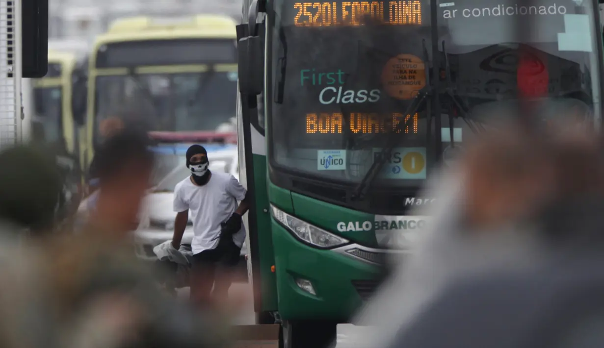 Seorang pria bersenjata menyandera puluhan orang dalam bus di sebuah jembatan yang menghubungkan Kota Niteroi dengan Rio de Janeiro, Brasil, Selasa (20/8/2019). Pria tersebut mengancam akan membakar kendaraan berisi 37 orang itu. (AP Photo/Ricardo Cassiano/Agencia O Dia)