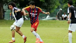 Pemain Paski-Man FC, Ajul Jiung (kiri) berebut bola dengan Vicky Nitinegoro (Selebriti FC) saat berlaga di turnamen Agum Gumelar Cup di Lapangan C Senayan, Jakarta (9/1/2015). Paski-Man FC unggul 1-0 atas Selebrity FC. (Liputan6.com/Helmi Fithriansyah