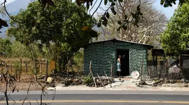 Nenek berusia 86 tahun, Maria Ponce berdiri di pintu rumahnya yang terbuat dari botol plastik bekas di Desa El Borbollon, El Transito, San Salvador, El Salvador 14 Maret 2017. Nenek ini membangun rumah pada 12 tahun silam. (AFP Photo/Marvin Recinos) 