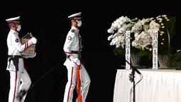 Anggota pengawal kehormatan membawa abu mantan Perdana Menteri Jepang Shinzo Abe ke altar saat pemakaman kenegaraan dimulai di Nippon Budokan, Tokyo, Jepang, 27 September 2022. Pemakaman kenegaraan untuk Shinzo Abe itu sejatinya menuai pro-kontra. (Philip Fong/Pool Photo via AP)