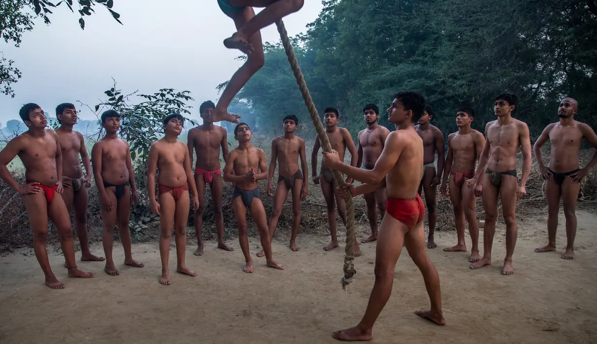 Sejumlah pegulat tradisional India berlatih panjat tali selama latihan harian mereka di semacam asrama gulat di Sabzi Mandi, New Delhi (20/11). (AP Photo/Dar Yasin)