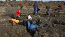 Seorang pria beristirahat sementara yang lain menggali untuk mencari apa yang mereka yakini sebagai berlian setelah penemuan batu tak dikenal di desa KwaHlathi dekat Ladysmith, Afrika Selatan (15/6/2021). (AFP/Phill Magakoe)