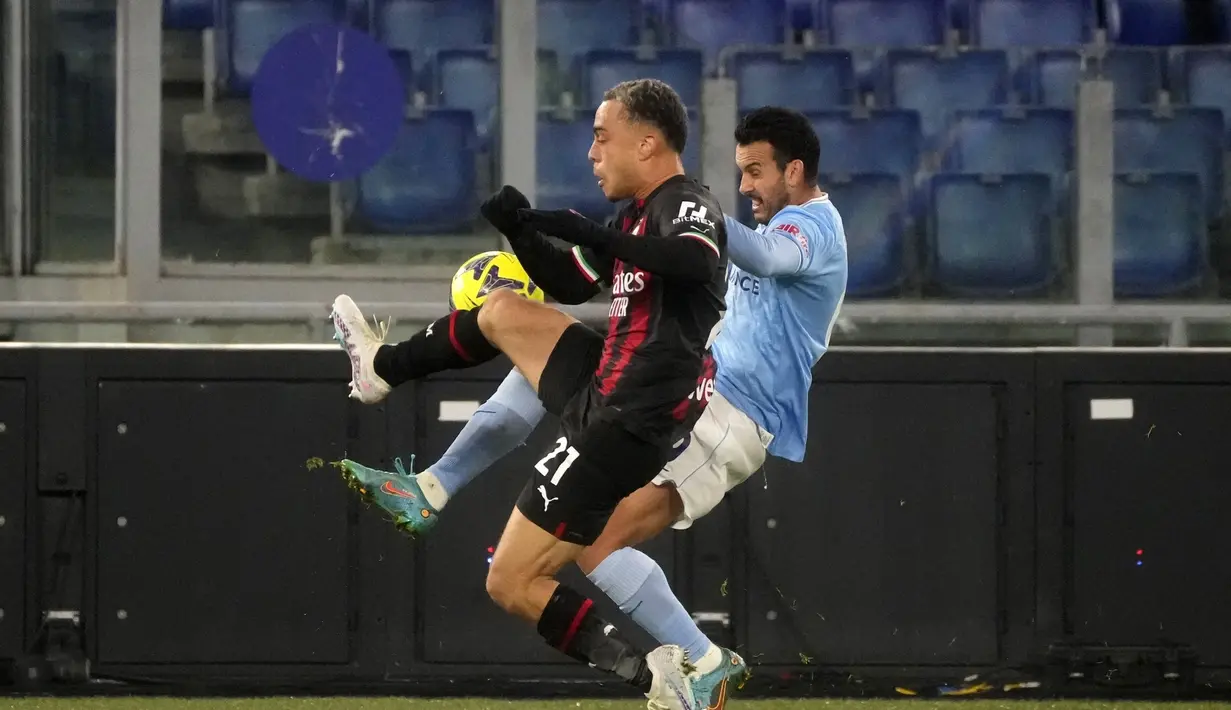Bek AC Milan, Sergino Dest berebut bola dengan penyerang Lazio, Pedro pada pertandingan lanjutan Liga Serie A Italia di Stadion Olimpiade di Roma, Rabu (25/1/2023). Lazio menang telak atas AC Milan dengan skor 4-0. (AP Photo/Gregorio Borgia)