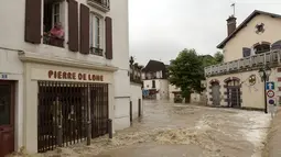 Seorang pria berada di jendela lantai pertama menyaksikan banjir merendam jalanan setelah hujan lebat di Salies-de-Bearn, Perancis barat daya (13/6). (AFP Photo/Iroz Gaizka)
