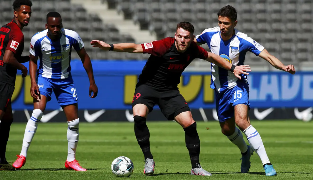 Pemain Hertha Berlin, Marko Grujic, berebut bola dengan pemain Augsburg, Eduard Lowen, pada laga Bundesliga di Olympiastadion, Sabtu (30/5/2020). Hertha Berlin menang 2-0 atas Augsburg. (AP/Hannibal Hanschke)