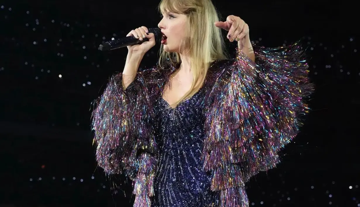 Tampilan super berkilau lainnya dari Taylor Swift. Dibalut one piece bodycon swimsuit berwarna biru tua penuh payet, Taylor tampak mengenakan lapisan lengan rumbai berwarna unicorn, serasi dan jelas patut diacungi jempol. Foto: Instagram.