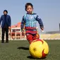 Murtaza Ahmadi (5) memakai kostum dari kantong kresek saat bermain sepak bola di markas Federasi Sepak Bola Afghanistan di Kabul, (2/2). Ahmadi tenar setelah fotonya dengan mengenakan kostum kresek "Messi" menyentuh hati netizen. (REUTERS / Omar Sobhani)