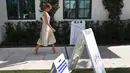 Ibu Negara Amerika Serikat Melania Trump tiba untuk memberikan suaranya pada Pilpres AS di Morton and Barbara Mandel Recreation Center, Palm Beach, Florida, 3 November 2020. Melania menarik rambut cokelat panjangnya dan ditata jadi sanggul rendah dengan kesan messy. (Joe Raedle/Getty Images/AFP)