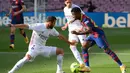 Gelandang Barccelona, Ansu Fati, berebut bola dengan bek Real Madrid, Nacho Fernandez, pada laga lanjutan Liga Spanyol di Camp Nou Stadion, Sabtu (24/10/2020) malam WIB. Real Madrid menang 3-1 atas Barcelona. (AFP/Lluis Gene)