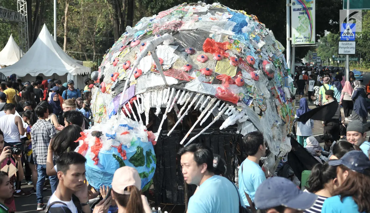 Karya instalasi "monster plastik" dalam pawai bebas plastik di Taman Aspirasi Monas, Jakarta, Minggu (21/7/2019). Monster plastik menyerupai ikan Angler Fish setinggi 4 meter itu sebagai bentuk bahaya atau dampak buruk penggunaan kantong plastik sekali pakai. (merdeka.com/Iqbal S Nugroho)