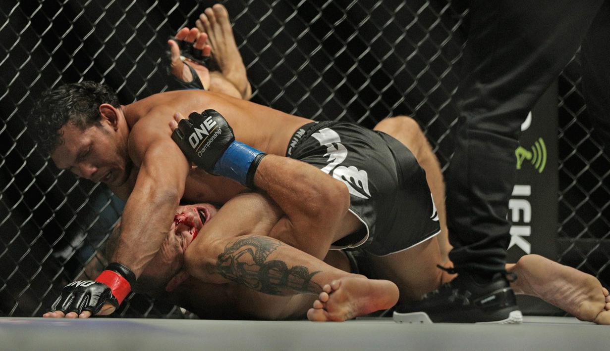 Luis Santos berhasil mengunci Igor Svirid di kelas welter laga tarung bebas MMA bertajuk One Championship di Jakarta. (Bola.com/Peksi Cahyo)