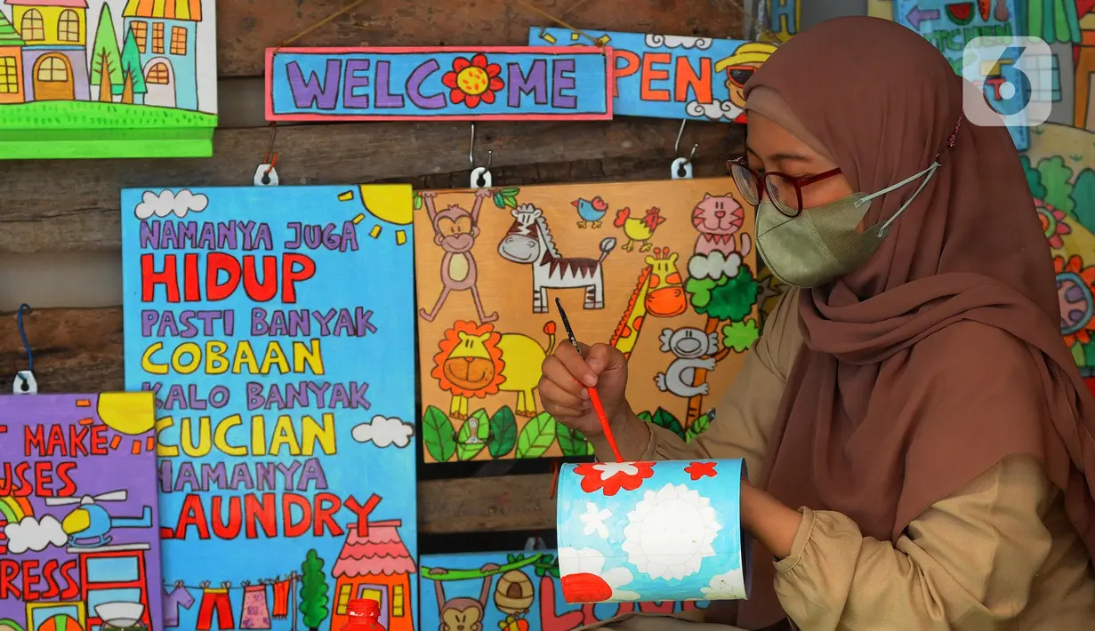 Perajin melukis bahan daur ulang untuk dipasarkan secara online di Kaleng Lani  di kawasan Tanah Baru, Depok, Jawa Barat, Rabu (9/3/2022). Setiap bulannya perajin mampu memberikan pendapatan ekonomi keluarga antara Rp 5 juta hingga Rp 7,5 juta. (merdeka.com/Arie Basuki)