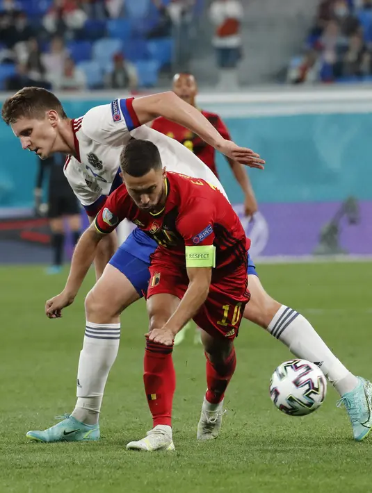 Gelandang timnas Belgia Eden Hazard berebut bola dengan bek Rusia, Igor Diveyev pada Matchday 1 Grup B Euro 2020 di Stadion Saint-Petersburg, Minggu (13/6/2021) dini hari WIB. Rusia berhasil mengandaskan Rusia 3-0 dengan dua gol dari Romelu Lukaku. (Anatoly Maltsev/Pool via AP)