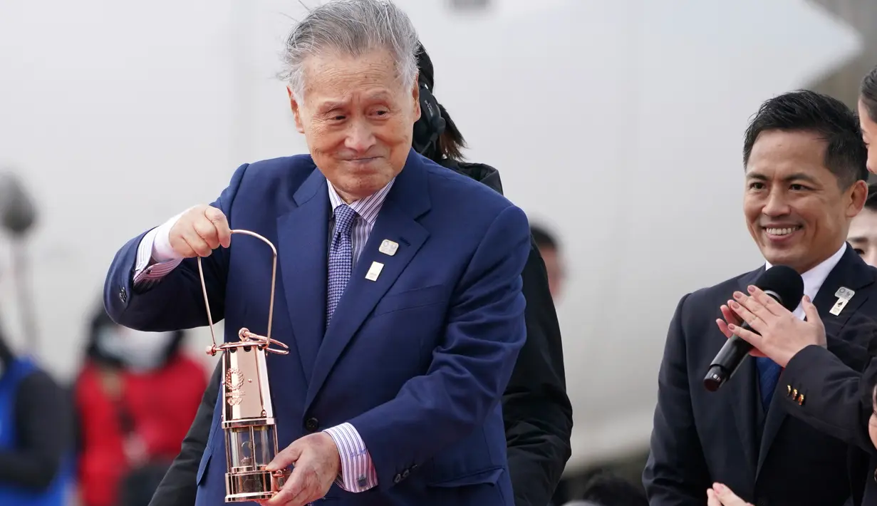 Presiden Olimpiade Tokyo 2020 Yoshiro Mori membawa api untuk obor Olimpiade Tokyo 2020 saat tiba dari Yunani di Pangkalan Udara Matsushima, Prefektur Miyagi, Jepang, Jumat (20/3/2020). Jepang bersikeras menyelenggarakan Olimpiade 2020 tepat waktu di tengah ancaman Covid- 19 . (AP /Eugene Hoshiko)
