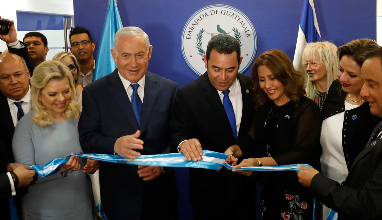 PM Israel Benjamin Netanyahu beserta istri dan Presiden Guatemala Jimmy Morales menyaksikan Ibu Negara Guatemala Hilda Patricia Marroquin memotong pita dalam upacara peresmian Kedubes Guatemala di Yerusalem, Rabu (16/5). (Ronen Zvulun/Pool Photo via AP)