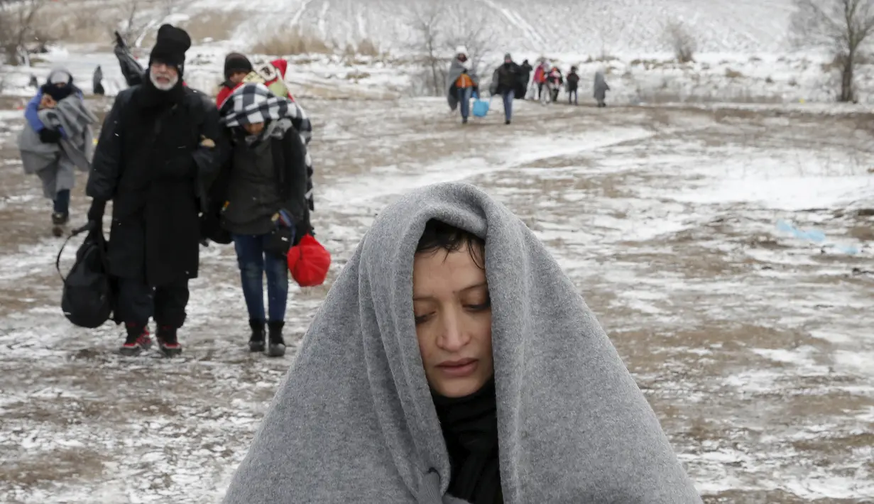 Seorang imigran terlihat lelah saat berjalan melewati hamparan salju setelah menyeberang dari perbatasan Macedonia di dekat desa Miratovac, Serbia, (18/1/2016). (REUTERS/Marko Djurica)