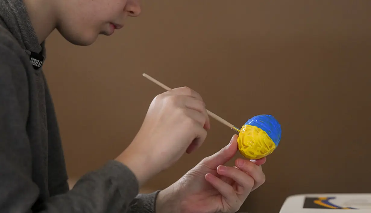 <p>Pengungsi anak-anak Ukraina melukis telur Paskah pada Kamis Putih di sebuah pusat pengungsi di Bucharest, Rumania, 21 April 2022. Orang Rumania yang mayoritas jemaat Ortodoks merayakan Minggu Paskah pada 24 April. (AP Photo/Andreea Alexandru)</p>