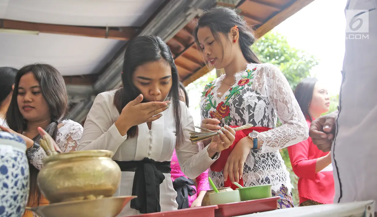 Umat Hindu meminum air suci seusai sembahyang di Pura Aditya Jaya, Jakarta, Sabtu (17/3). Sembahyang tersebut dilakukan untuk perayaan Hari Raya Nyepi Tahun Baru Saka 1940. (Liputan6.com/Herman Zakharia)