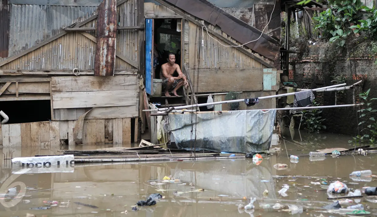 Warga menunggu banjir surut di kawasan Cawang, Jakarta, Selasa (21/2). Akibat curah hujan yang tinggi sejumlah pemukiman di bantaran Ciliwung kelurahan Cawang dan Rawajati terendam banjir. (Liputan6.com/Yoppy Renato)
