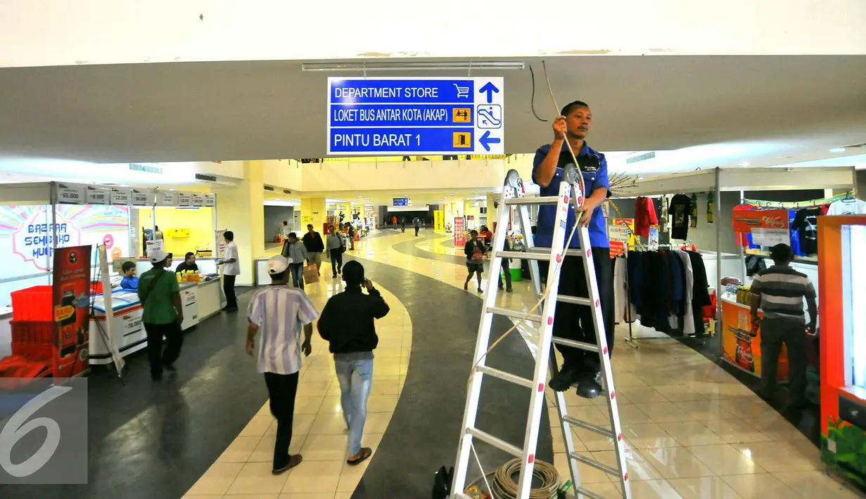 Pekerja memasang penunjuk arah di terminal terpadu Pulo Gebang, Jakarta, Selasa (27/12). Rencananya, terminal ini akan diresmikan pada 28 Desember nanti. (Liputan6.com/Angga Yuniar)