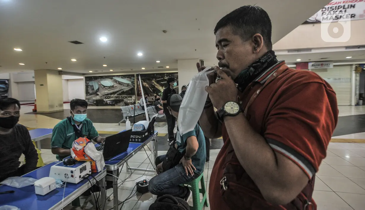 Calon penumpang menjalani tes Genose sebagai salah satu syarat berpergian di Terminal Pulogebang, Jakarta, Senin (10/5/2021). Pemberlakuan larangan mudik dan syarat wajib memiliki SIKM menyebabkan jumlah penumpang di Terminal Pulogebang merosot drastis. (merdeka.com/Iqbal S Nugroho)