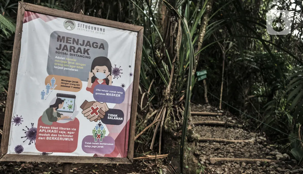 Poster imbauan protokol kesehatan Covid-19 terpasang di salah satu jalur menuju Jembatan Gantung Situ Gunung, Sukabumi, Jawa Barat, Minggu (20/9/2020).  (merdeka.com/Iqbal S. Nugroho)