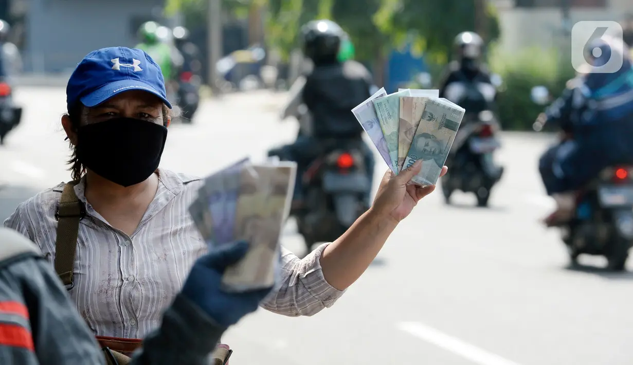 Penjual jasa penukaran uang menawarkan uang baru berbagai pecahan kepada pengguna jalan di kawasan Bintaro Sektor 2, Jakarta Selatan, Selasa (12/05/2020). Menjelang perayaan Lebaran, jasa penukar uang keliling yang berada di pinggir jalan-jalan utama mulai bermunculan. (merdeka.com/Dwi Narwoko)