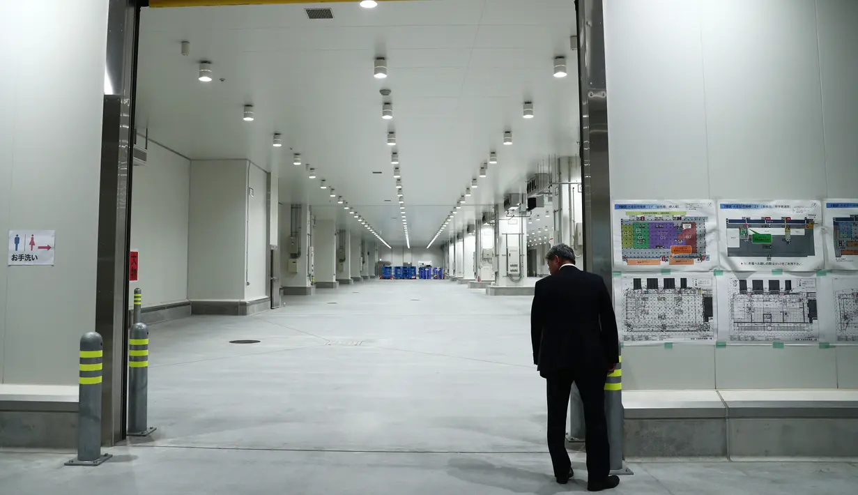 Seorang pria melihat bagian dari pasar ikan Toyosu sebelum upacara pembukaan, di Tokyo, Kamis (13/9). Disini akan menjadi lokasi baru untuk Pasar Ikan Tsukiji yang jadi destinasi wisata favorit yang telah dibuka sejak tahun 1935. (AFP/Behrouz MEHRI)