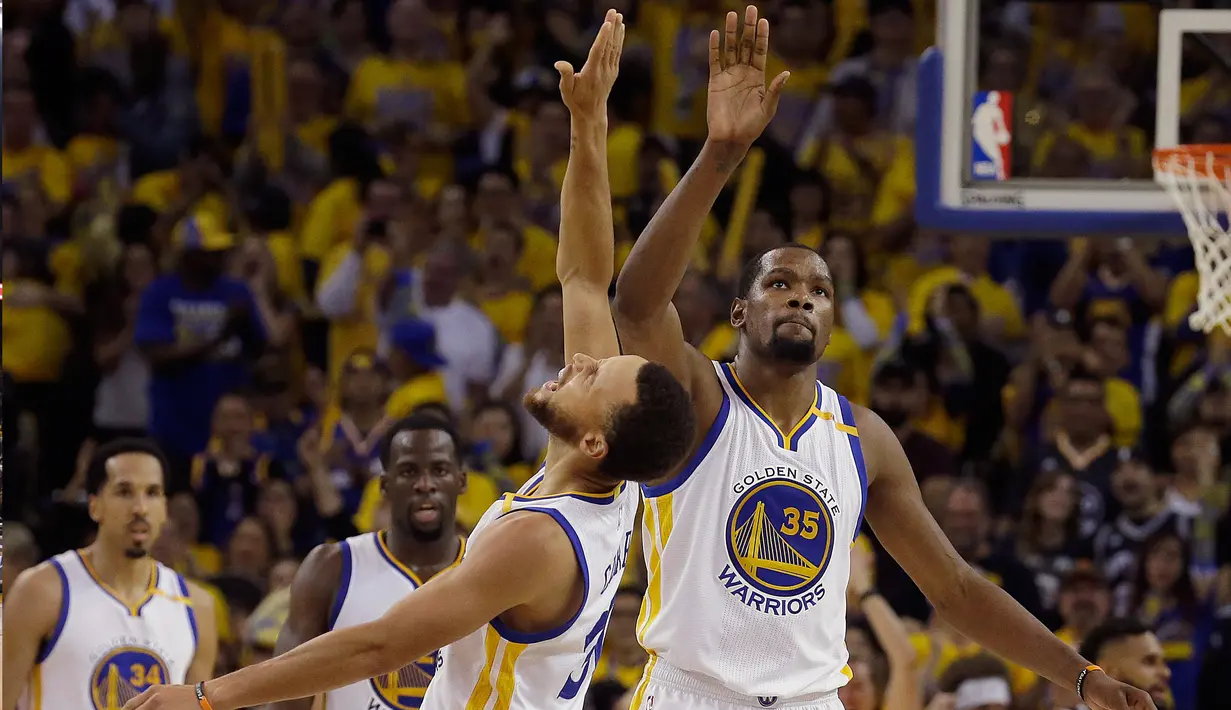 Pemain Golden State Wariors, Stephen Curry dan Kevin Durant merayakan kemenangan timnya usai berhadapan dengan San Antonio Spurs di gim pertama final Wilayah Barat playoffs NBA 2017 di Oakland, California (14/5). (AP Photo/Jeff Chiu)
