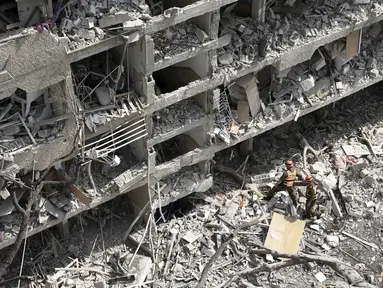 Perwira komando garis depan Israel meninjau lokasi serangan rudal langsung yang diluncurkan dari Iran di Tel Aviv, Minggu 22 Juni 2025. (AP/Oded Balilty)