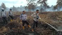 Petugas mendinginkan kebakaran di lahan gambut agar apinya benar-benar padam. (Liputan6.com/M Syukur)