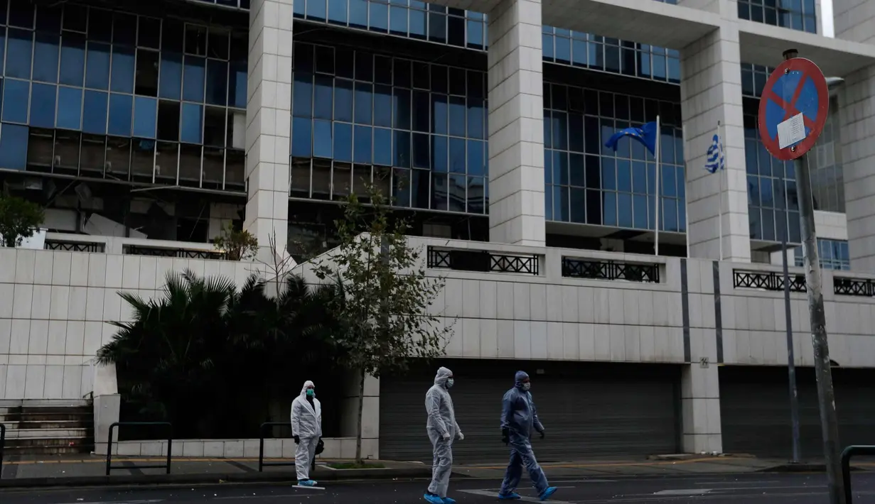 Petugas kepolisian mencari barang bukti usai ledakan bom di Pengadilan Banding di Athena, Jumat, (22/12). Polisi Yunani melaporkan tidak ada korban jiwa akibat kejadian tersebut. (AP Photo / Thanassis Stavrakis)