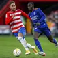 Pemain Real Madrid, Ferland Mendy (kanan) mencoba menghindari pengawalan pemain Granada, Ruben Rochina, dalam lanjutan Liga Spanyol, Minggu (21/11/2021) malam WIB. (AP Photo/Fermin Rodriguez)