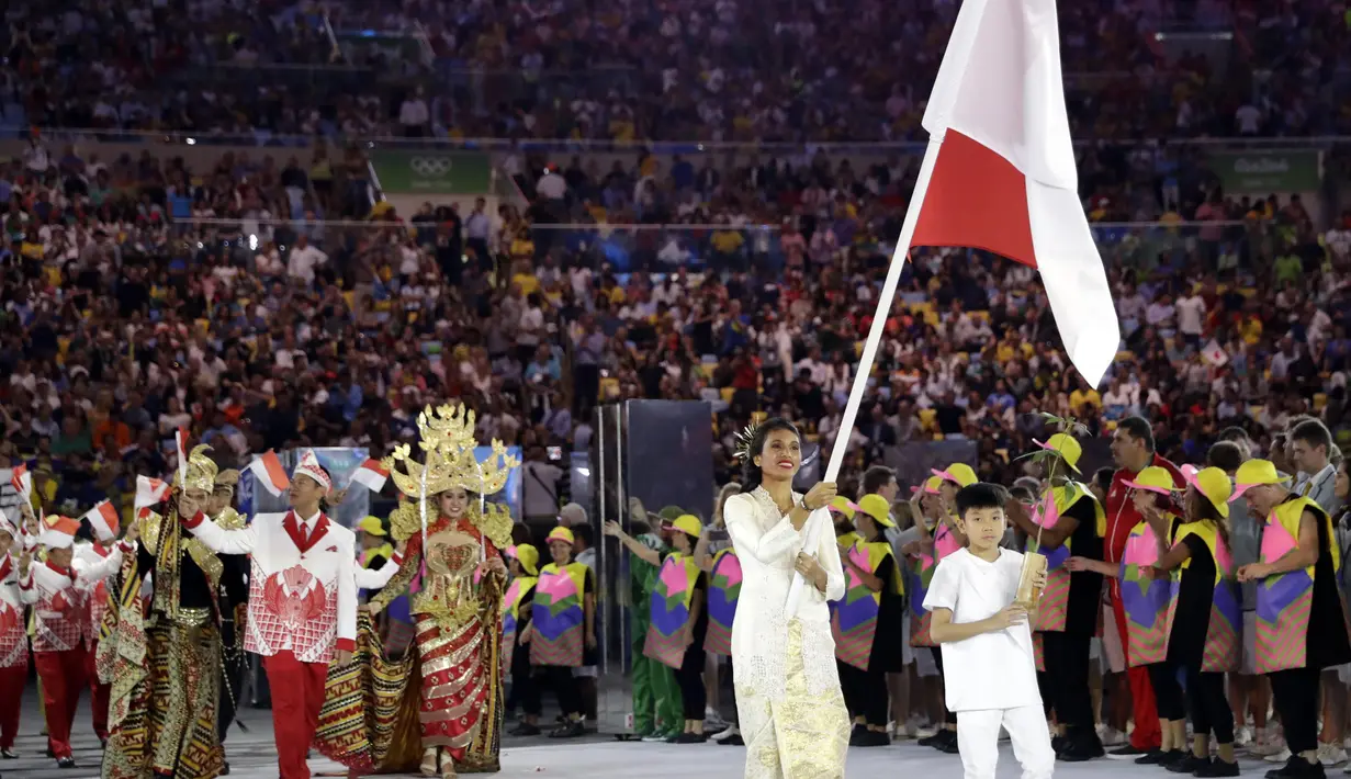 Atlet lompat jauh Indonesia, Maria Londa membawa bendera Merah-Putih saat memimpin kontingen Indonesia pada sesi perkenalan Negara peseerta Olimpiade Rio 2016 di Rio de Janeiro, Brazil (5/8/2016). (AP Photo/David J. Phillip)