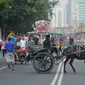 Sebuah delman main kucing-kucingan dengan petugas car free day di Bundaran HI. (Liputan6.com/Gempur M Surya)