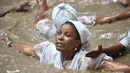 Seorang wanita pengikut Voodoo Haiti mandi di kolam suci selama upacara Voodoo di Souvenance, Haiti (4/1). Sejumlah ritual digelar para pengikuti Voodoo Haiti ini selam akhir pekan perayaan Paskah. (AFP/Hector Retamal)