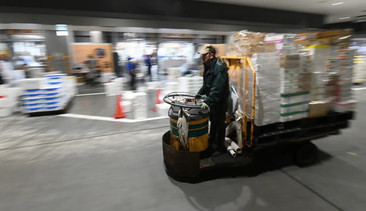 Pekerja mengoperasikan truk turret di antara toko-toko pada hari pertama pembukaan pasar ikan Toyosu yang baru,  di Tokyo, Kamis (11/9). Pasar ikan Toyosu menggantikan pasar ikan legendaris yang sudah mendunia, Pasar Tsukiji. (Toshifumi KITAMURA/AFP)