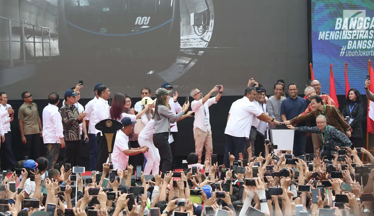 Presiden Joko Widodo (tengah) bersama Gubernur DKI Jakarta, Anies Baswedan saat peresmian pengoperasian Moda Raya Terpadu Jakarta fase 1 sekaligus pencanangan pembangunan MRT fase 2. di kawasan Bundaran HI, Minggu (24/3). (Liputan6.com/Helmi Fithriansyah)
