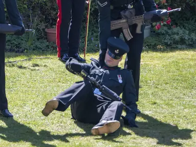 Seorang anggota The Rifles terjatuh menjelang pemakaman Pangeran Philip di luar Kapel St George di Kastil Windsor, Windsor, Inggris, Sabtu (17//4/2021). Prajurit yang tidak disebutkan namanya itu tampak tercengang saat dia jatuh ke tanah. (Arthur Edwards/Pool via AP)